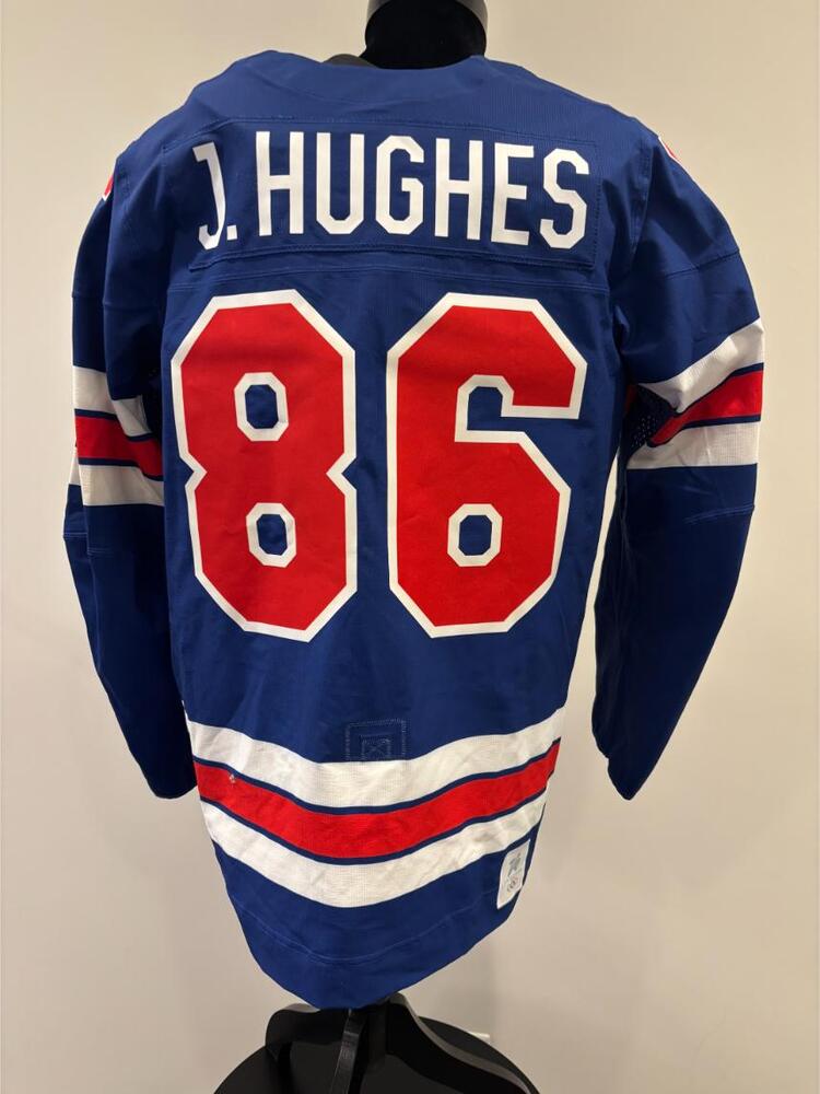 Jack Hughes USA Game-Used Blue Jersey worn v. Denmark on February 14, 2026, as a part of the 2026 Milano Cortina Winter Games.